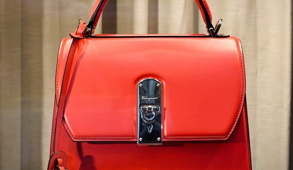 red leather handbag on white table